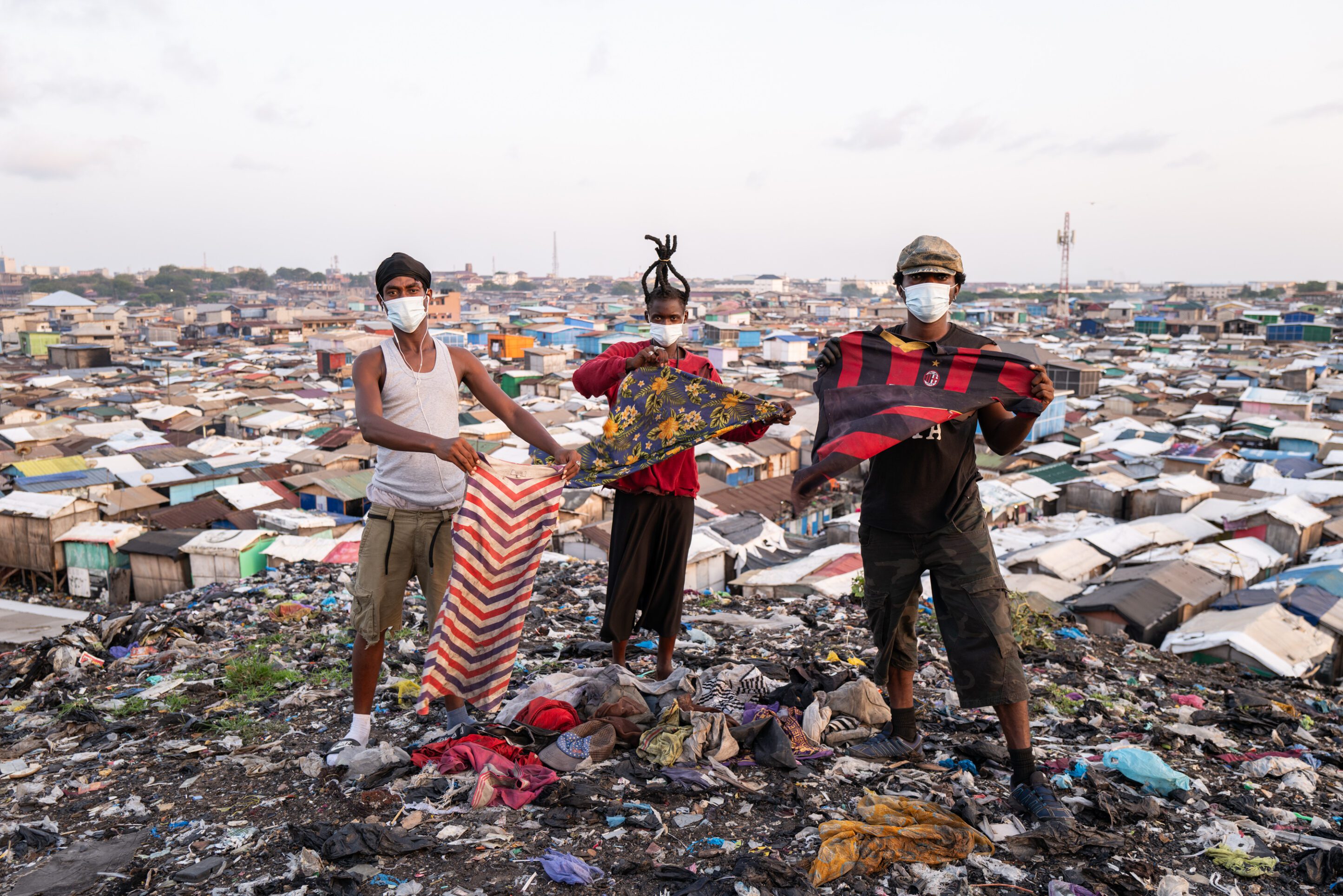 Brandneue Textilien werden von Textilunternehmen weggeworfen und landen auf überquellenden Müllhalden in Jamestown, Ghana, wo sie von Aktivist*innen ins Bild gehalten werden.