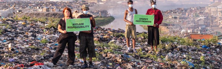 Aktivst*innen halten Schilder mit der Aufschrift 